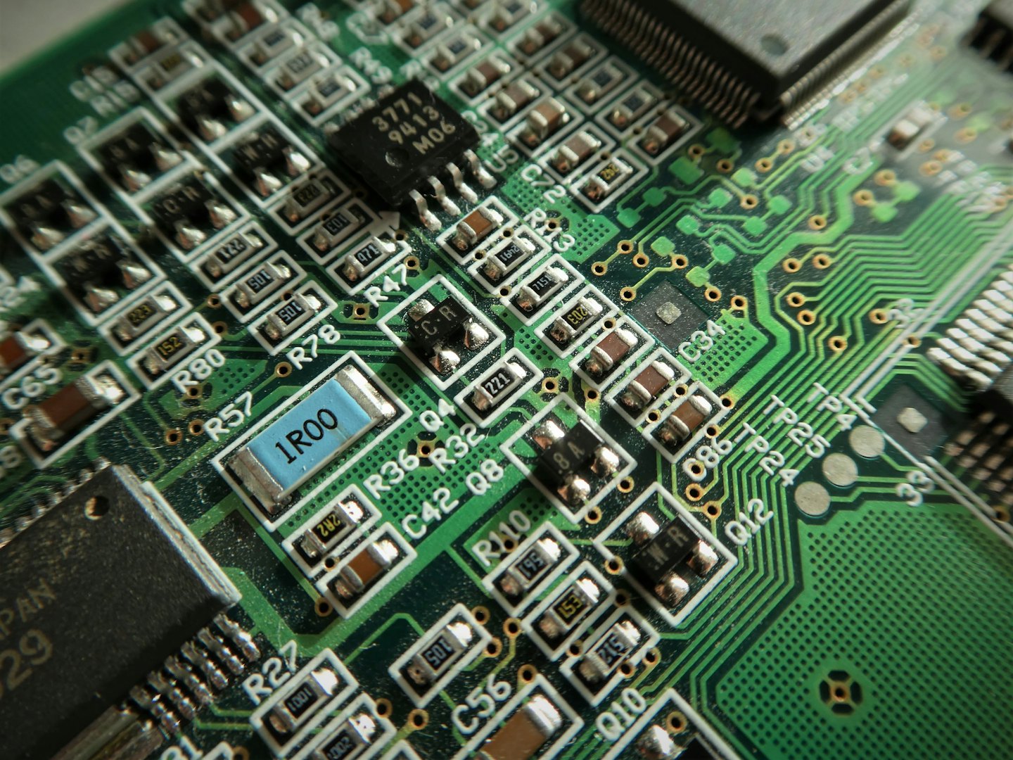 Grüne Leiterplatte mit vielen elektronischen Bauteilen.